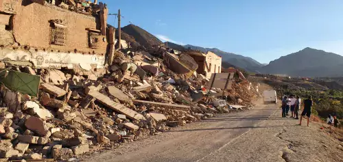 A road with rubble and destroyed houses