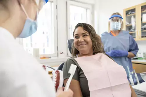 Dental treatment, patient in the chair with dentist and detnal nurse.