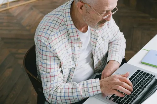 Elderly man with eyeglasses using latop